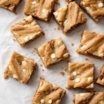 Snickerdoodle blondies on a wooden table with cinnamon sugar topping